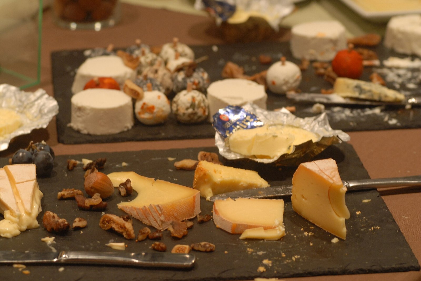 Wine glasses and a selection of cheeses on a table